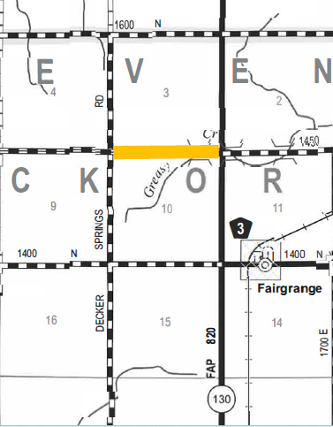 Section of a road map showing labeled grid areas E, V, E, N, C, K, O, R with roads including Springs Rd, Decker, FAP 820/130, and a highlighted horizontal road section in orange between 'V' and 'O' grids. Fairgrange town is marked with a location symbol near grid R. Road numbers 3 and 1400 are shown.