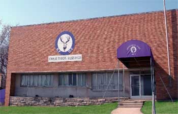 Brick building with a round Elks emblem featuring a stag and the text 'Child Union Elks 225' above a door with a purple awning displaying the Elks logo.