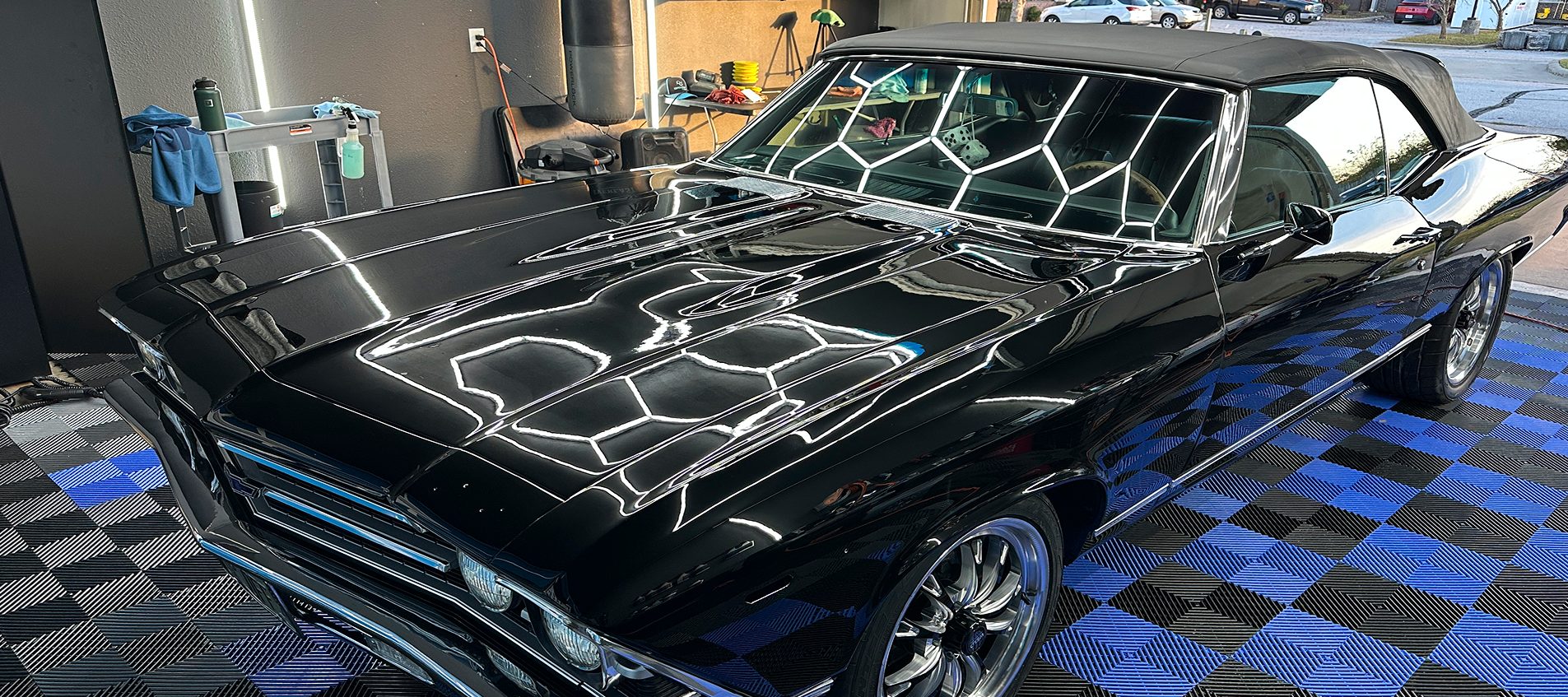 Black classic Chevelle with a fresh ceramic coating under hexagon lights in the Detail Armor studio