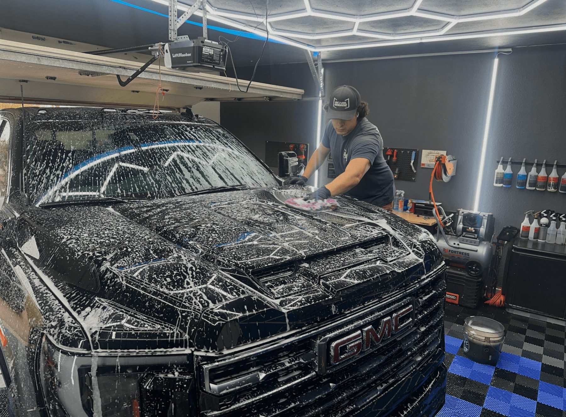 Gavin foam washing a GMC truck during a full detail in Springfield, MO