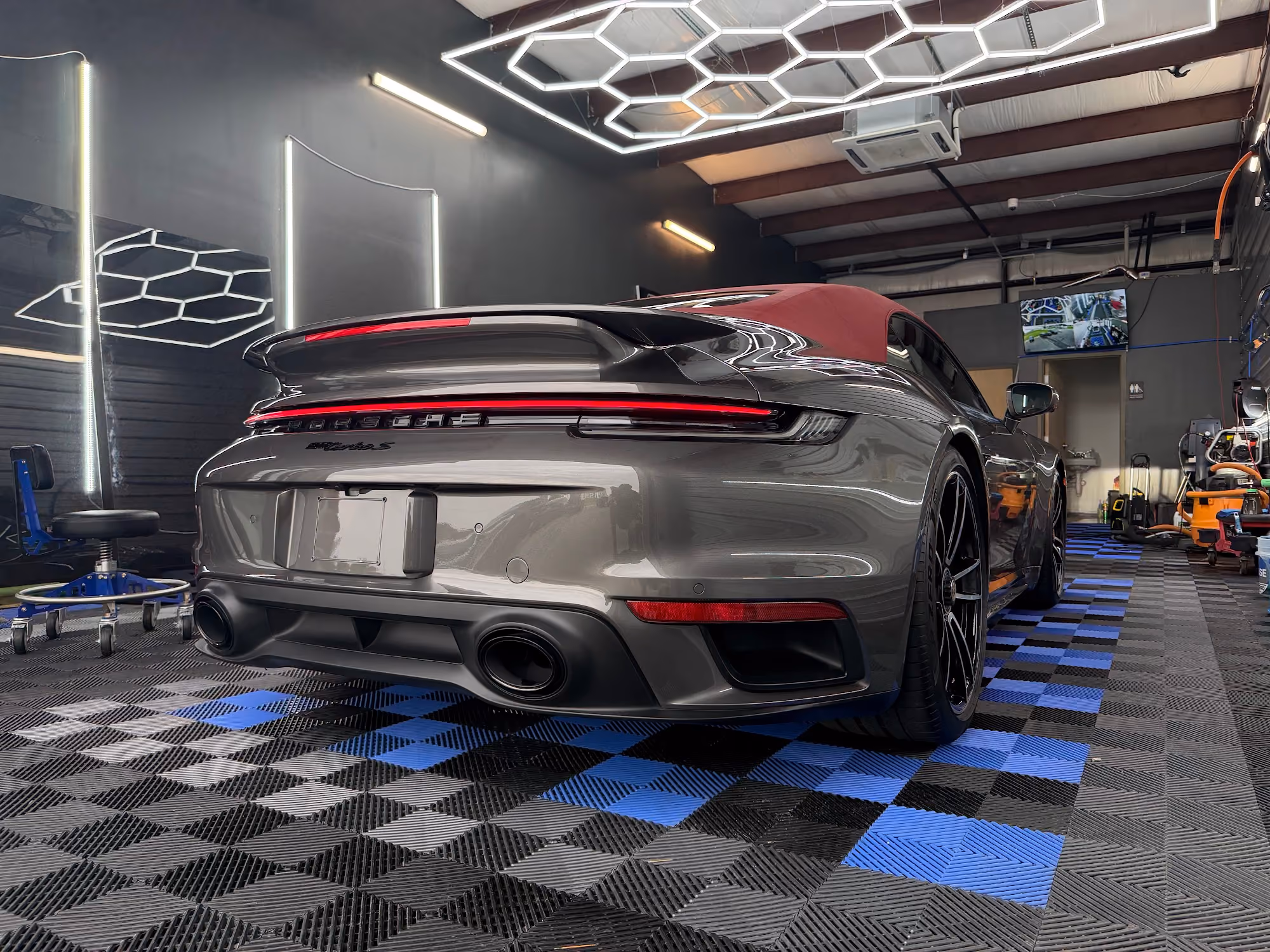 Gray Porsche 911 Turbo with tinted rear glass under hexagon lights at Detail Armor in Springfield, MO