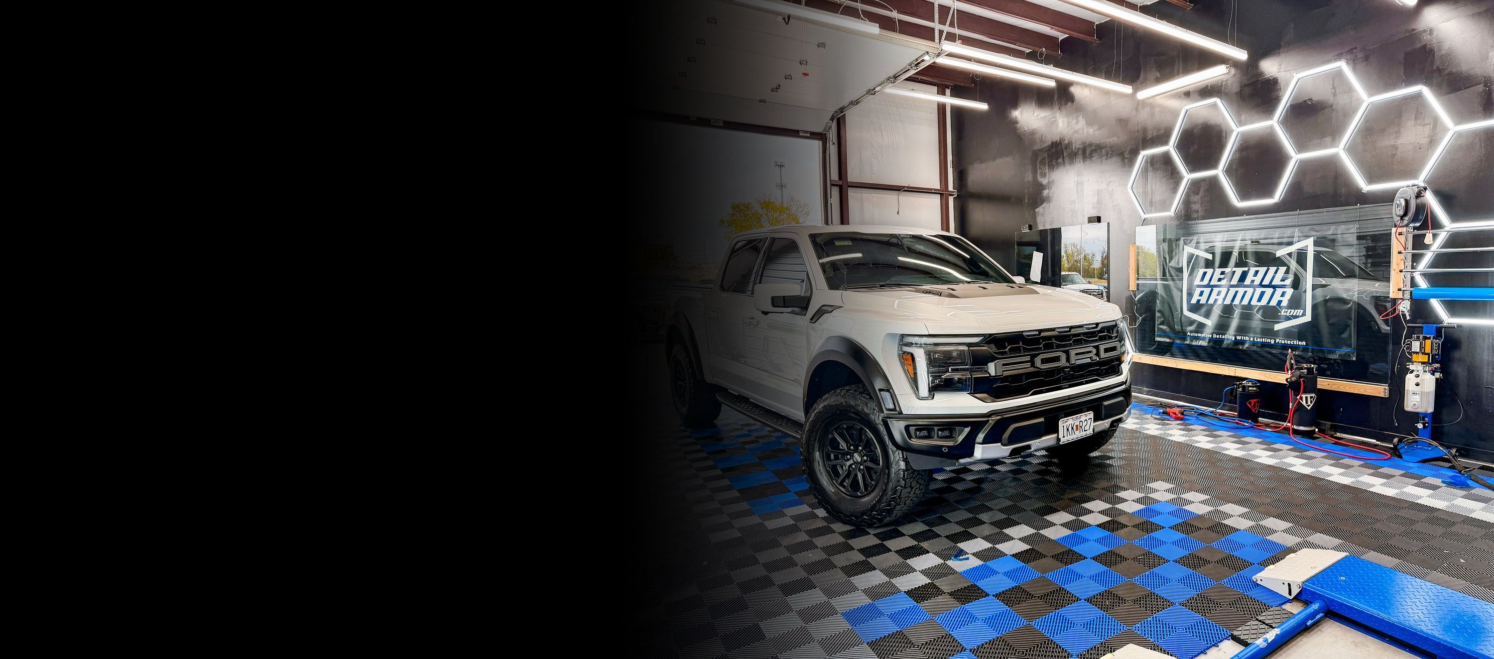White Ford Raptor R with paint protection film in the Detail Armor studio under hexagon lights