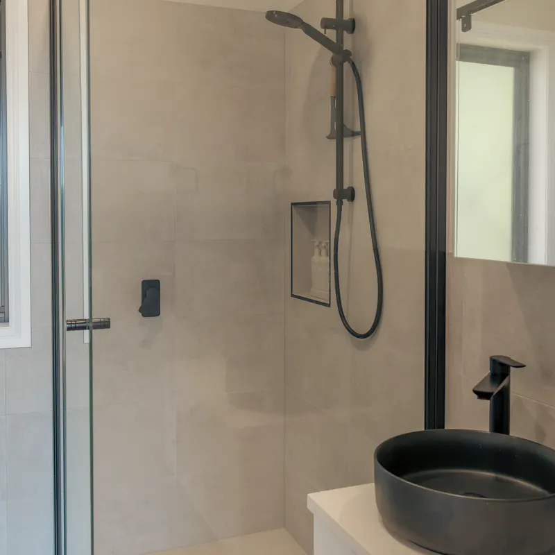 The bathroom's walk-in shower behind glass