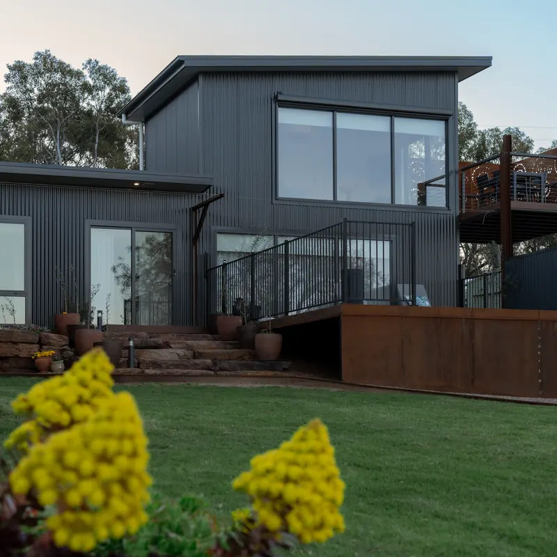 The accommodation seen from the lawn, with the garden beds in front