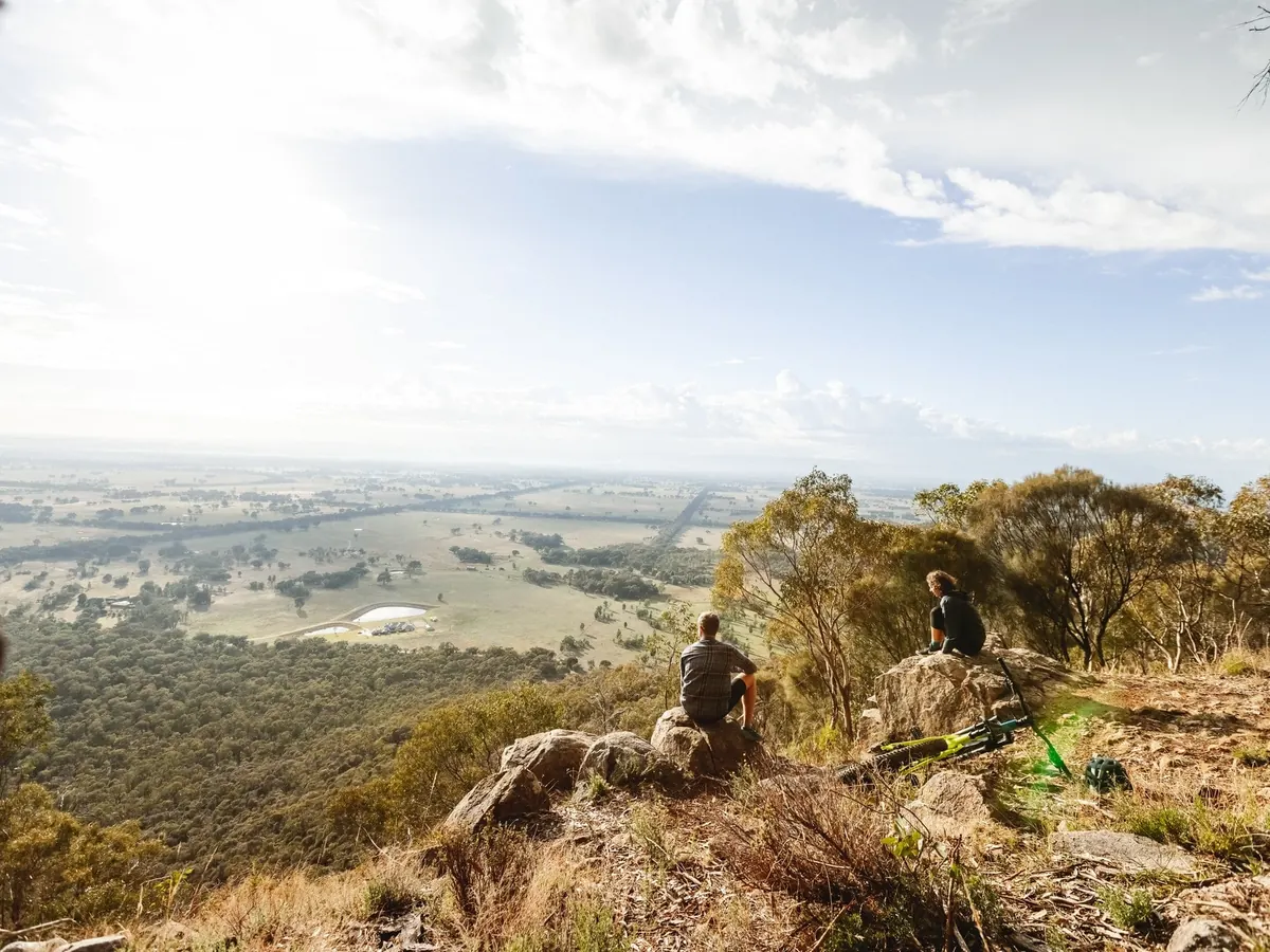 Walkers on a granite outcrop in the Warby Range National Park, looking over the plains