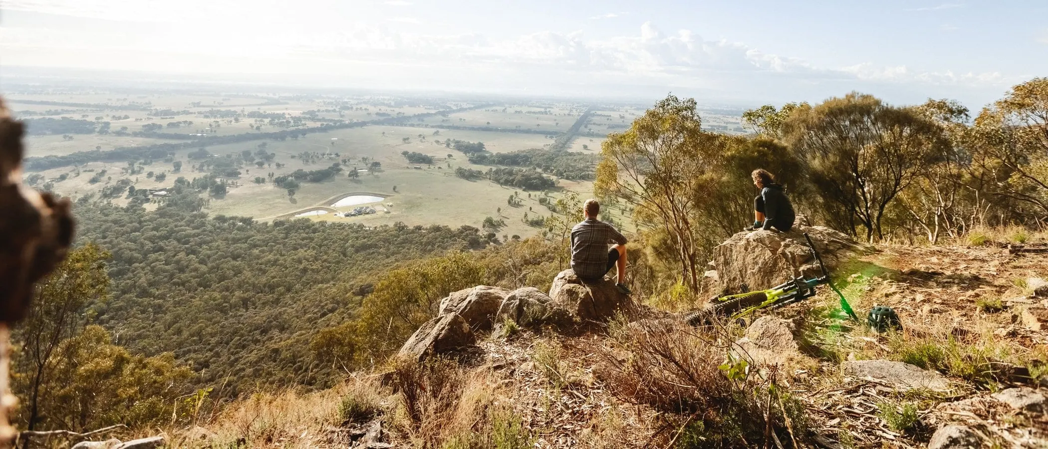 Walkers on a granite outcrop in the Warby Range National Park, looking over the plains
