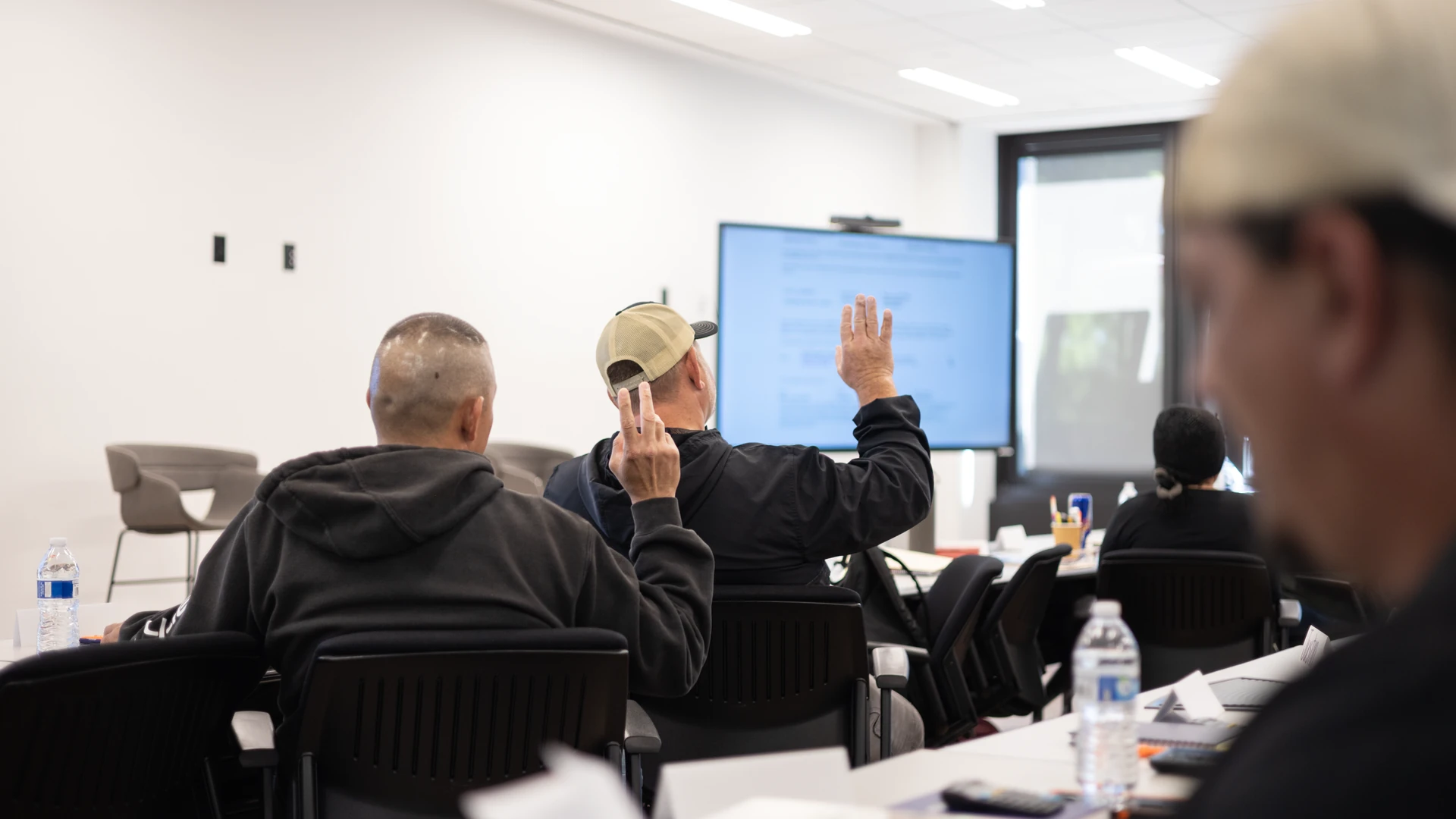 Students raising their hands during an exam prep class