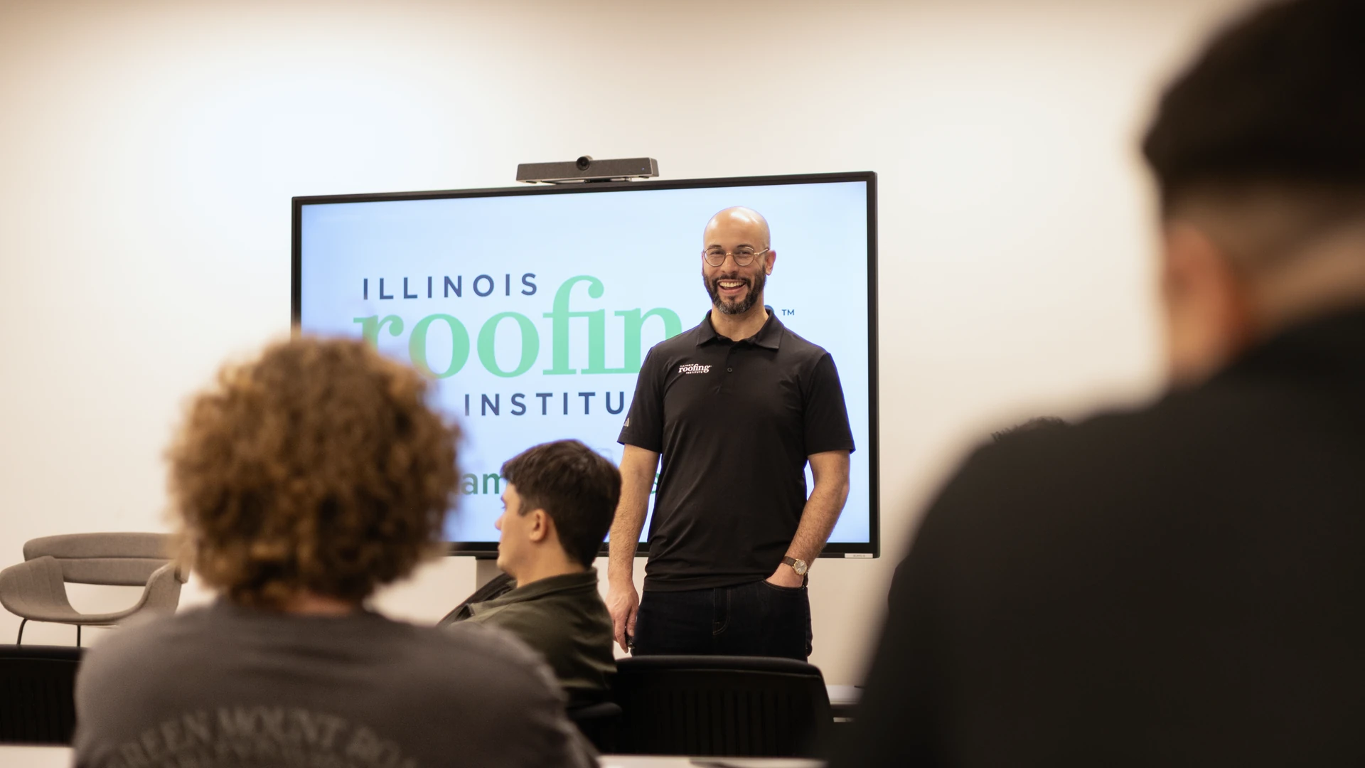Dante Sabel in front of the Illinois Roofing Institute logo during a class