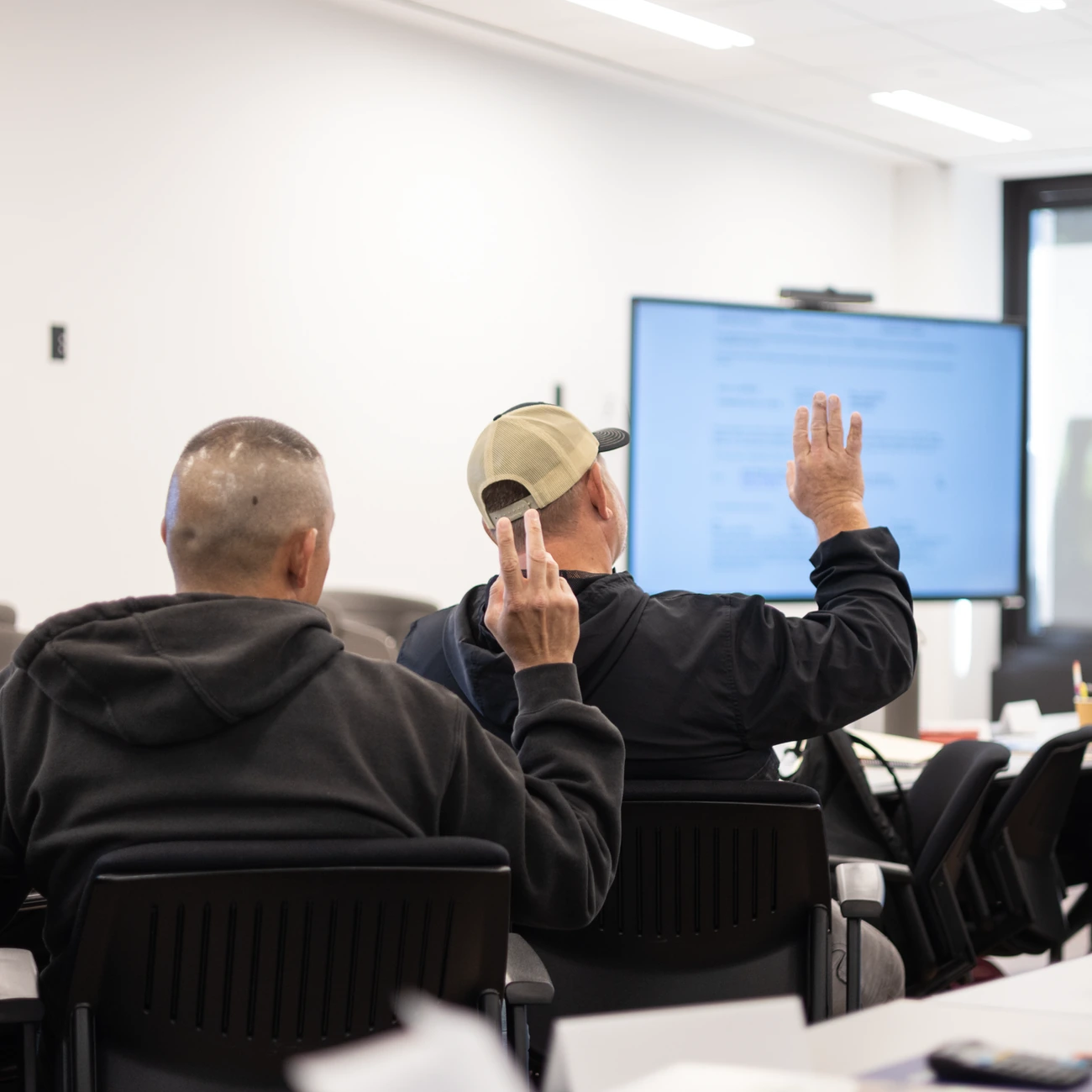 Students raising their hands during an Illinois Roofing Institute class