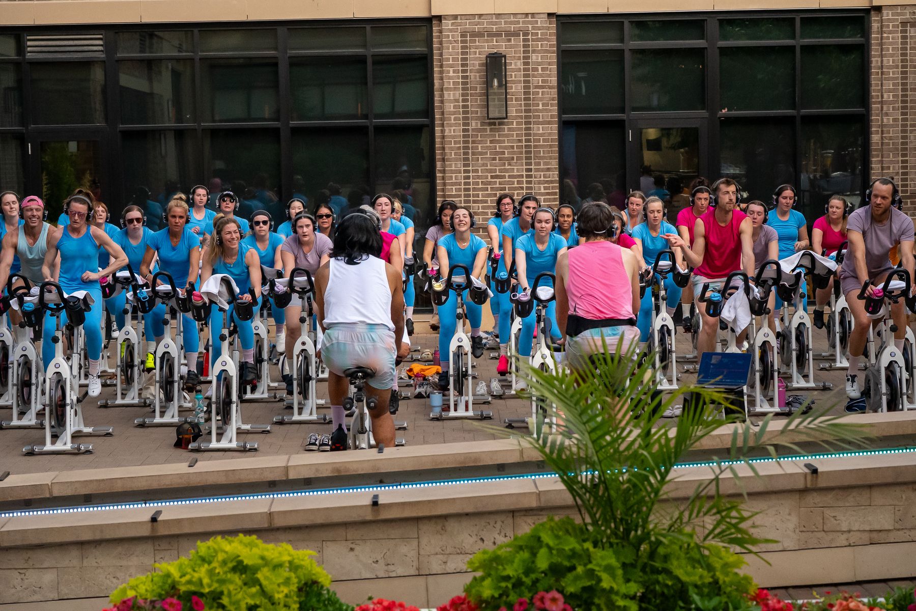 A full outdoor cycle class at The GRIND, rows of bikes and riders in matching shirts