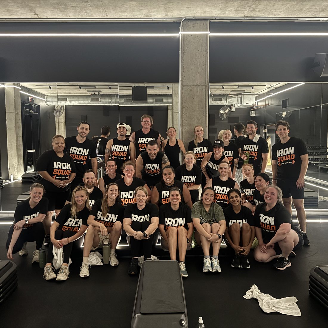 A strength room group in matching Iron Squad shirts after a team workout