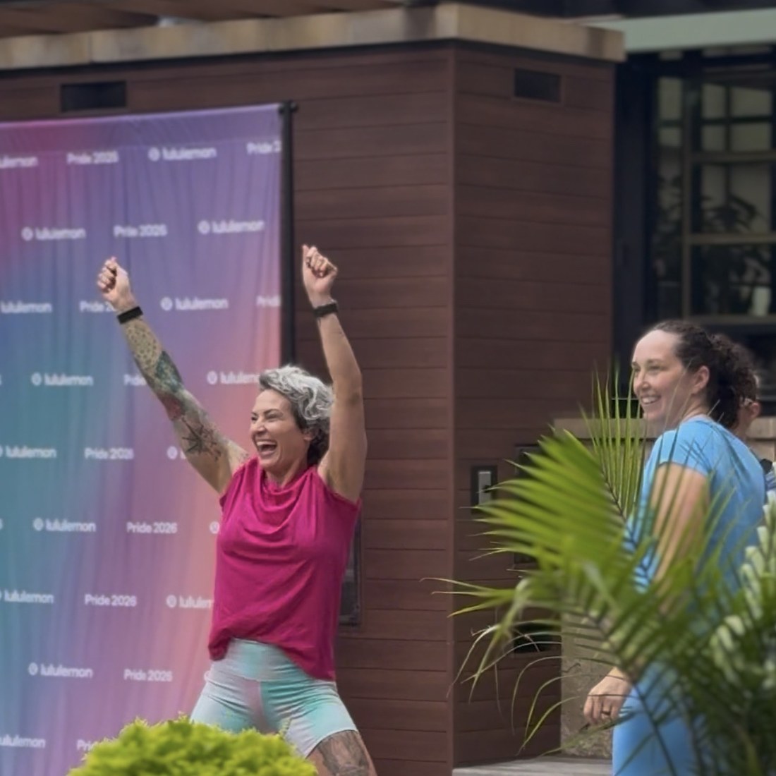Arms in the air at the end of an outdoor class at a lululemon Pride event
