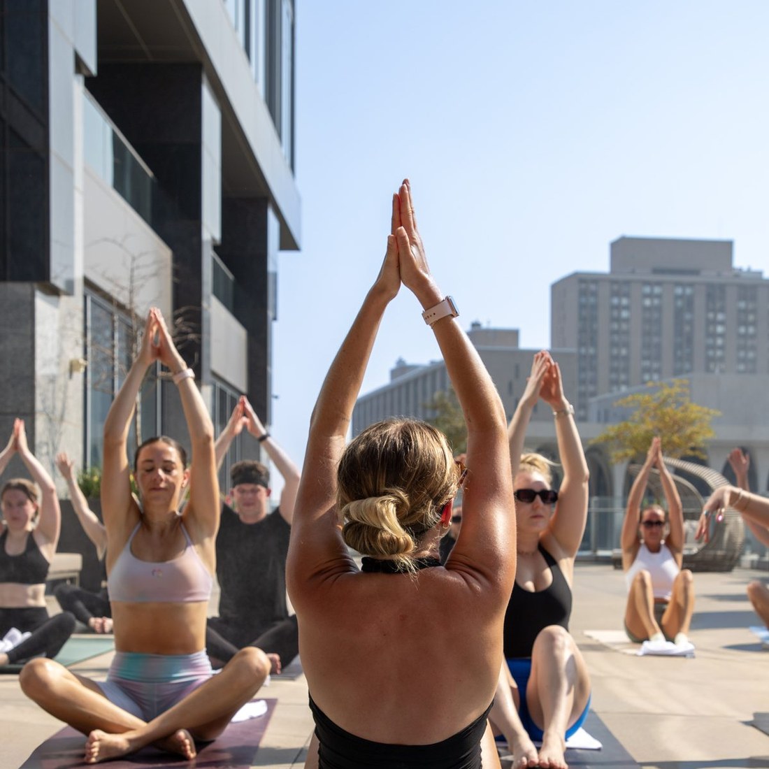 A rooftop restore class reaching overhead with the city skyline behind