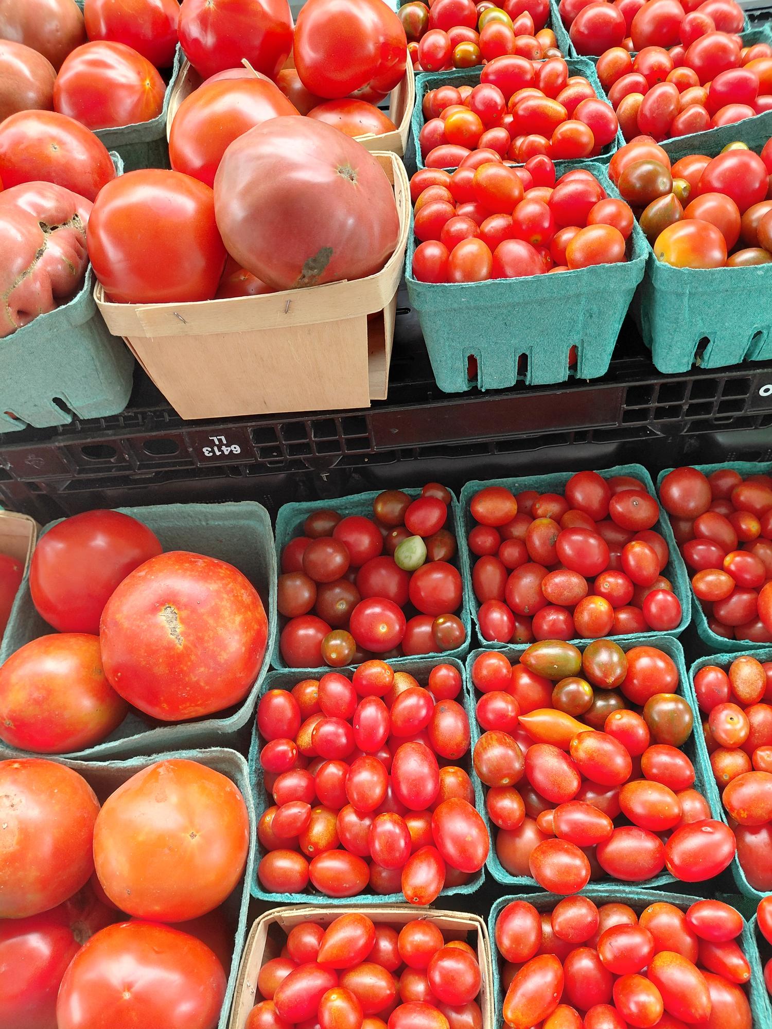 Slicer and cherry tomatoes in market baskets