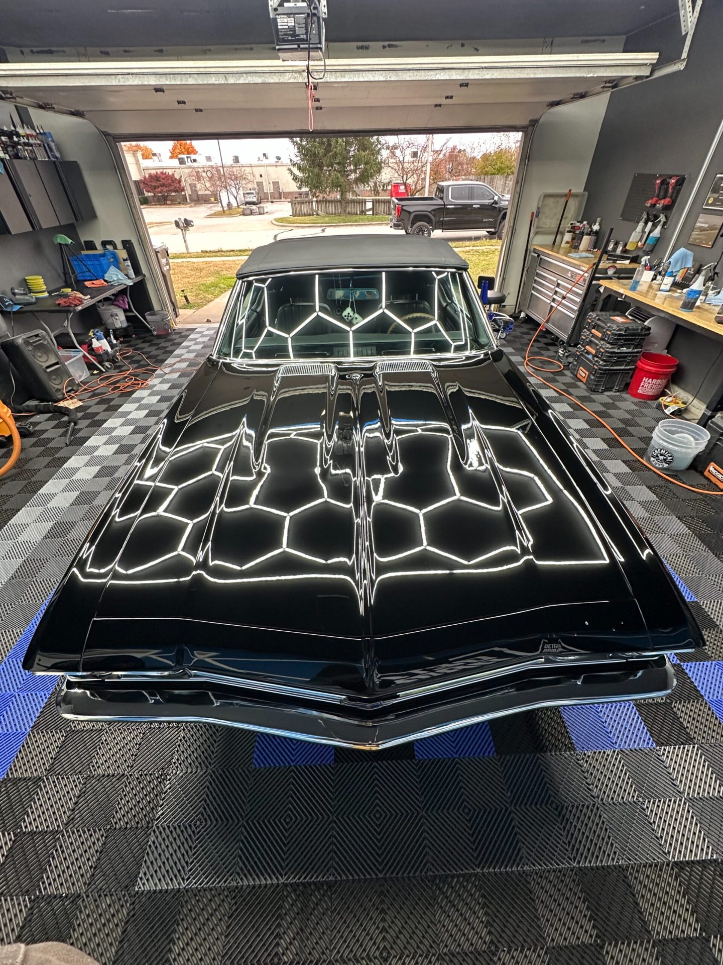 Black 1969 Chevy Chevelle SS after paint correction and a ceramic coating under hex lights