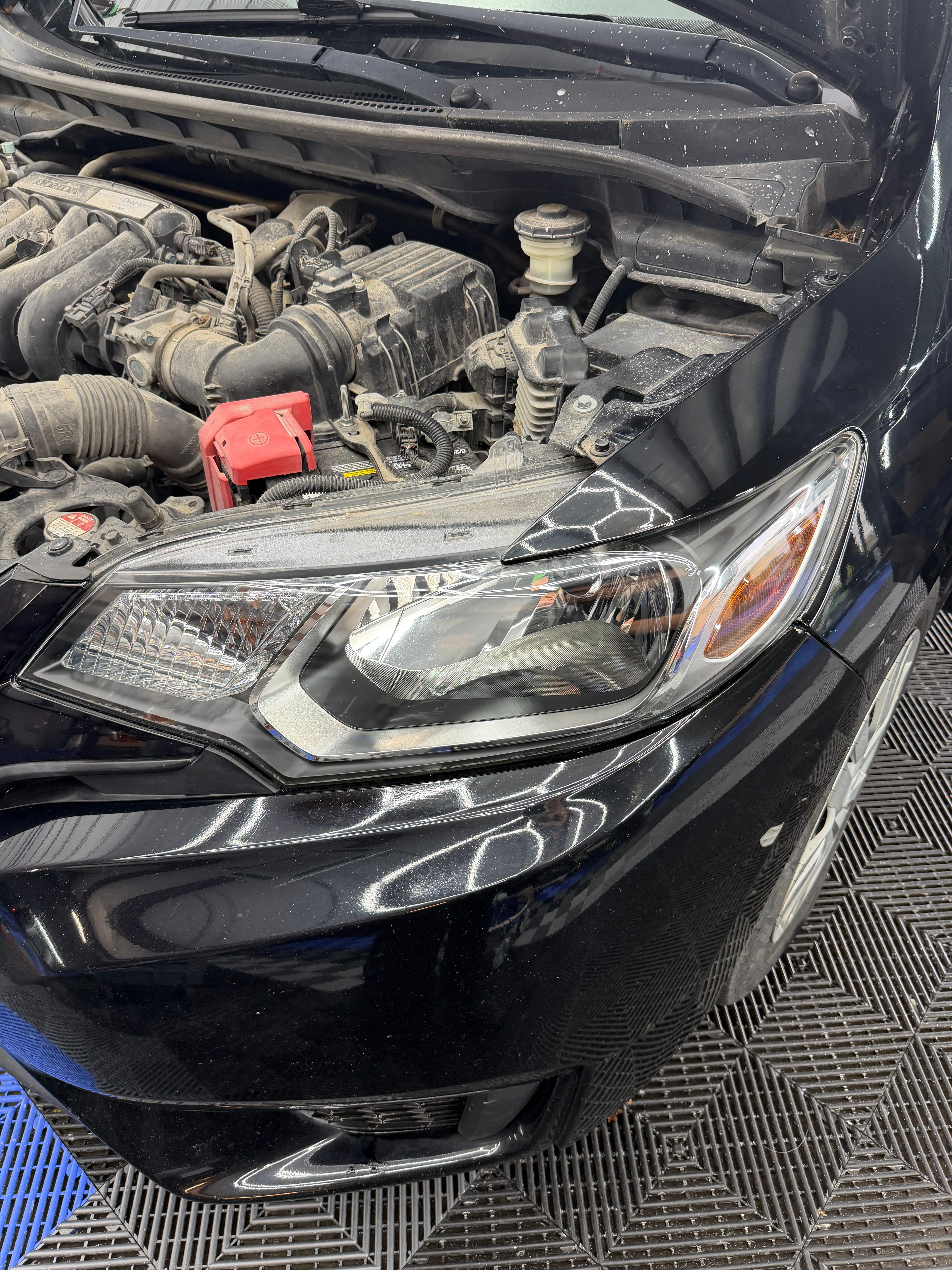Restored, clear headlight on a black car after headlight restoration at Detail Armor