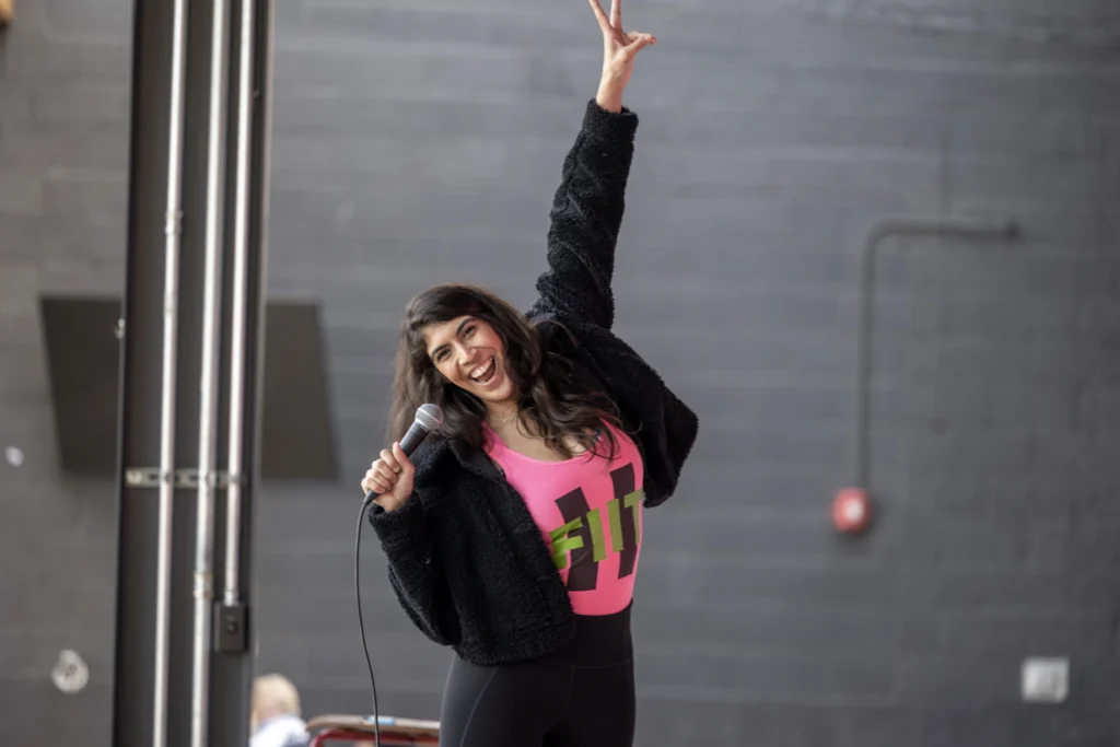 An event participant raising an arm beside a STRENGTH IN THE CITY banner.