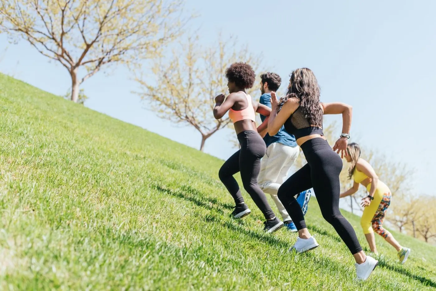 Attendees running up a grass hill