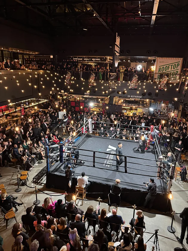 The ring between rounds, with a black-tie crowd on all four sides