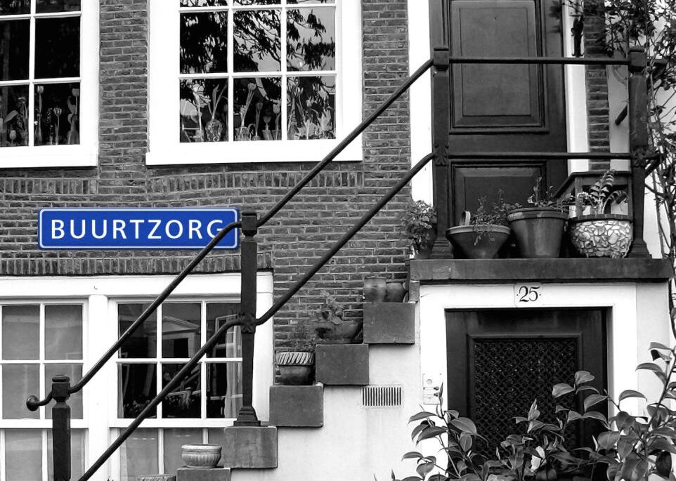 A Dutch canal house with a Buurtzorg sign