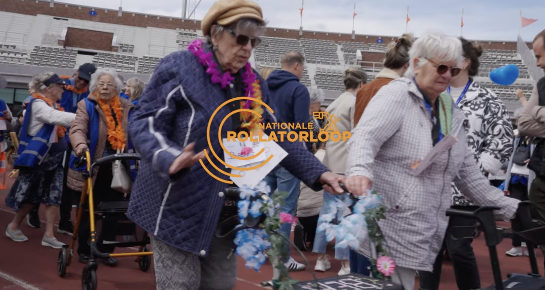 Participants with their walkers, wearing flower garlands, on the track at the Olympic Stadium during the 2025 National Walker Race