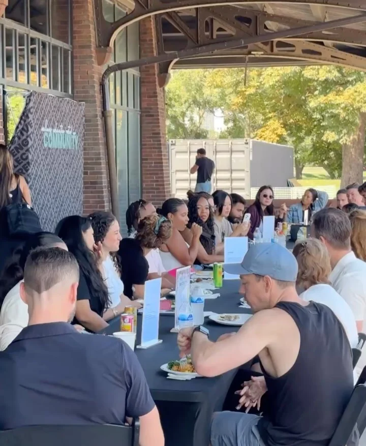 Attendees gathered around a long table for a conversation.