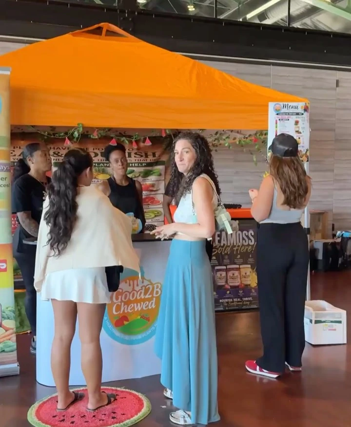 Attendees talking with vendors at a colorful product booth.