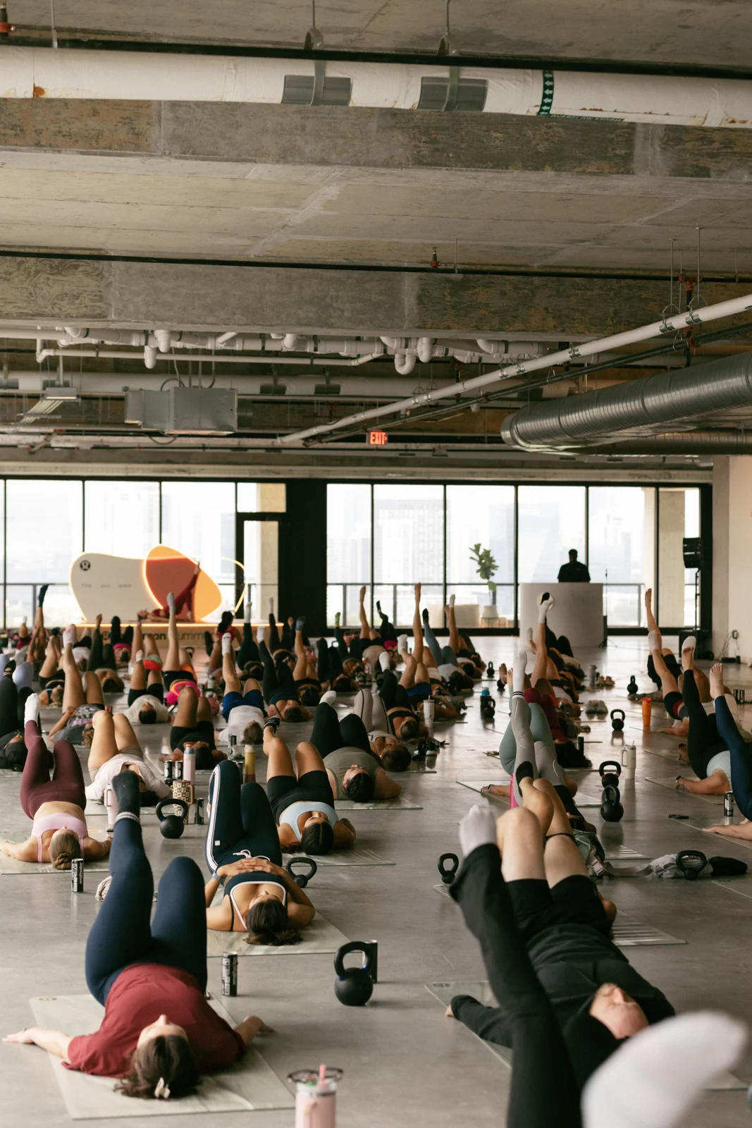 A group taking part in a mat class in a bright, open room.
