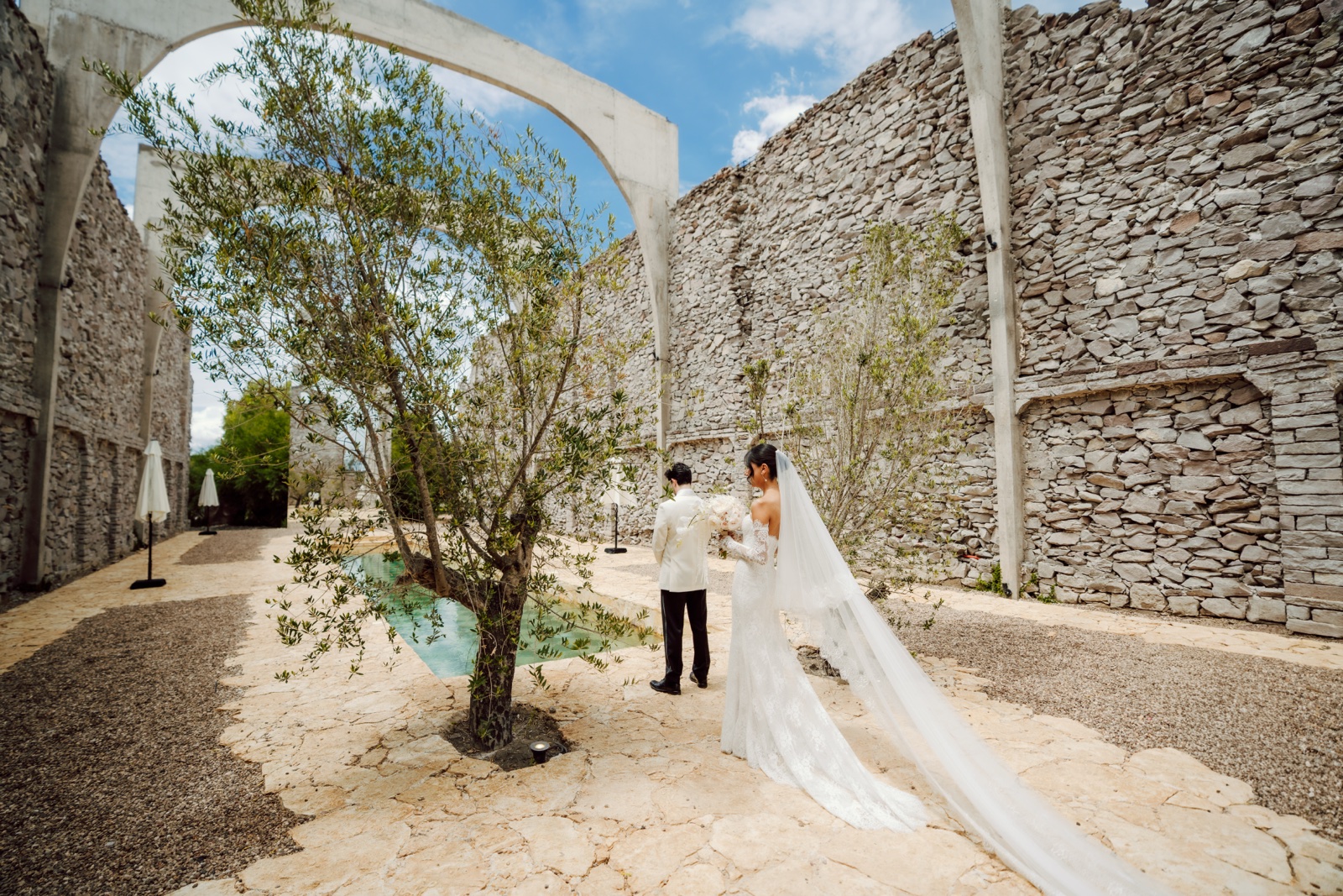 novios caminando entre los muros de piedra de la hacienda