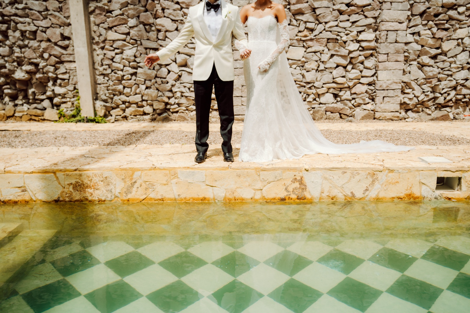 novio de pie junto al estanque de la hacienda