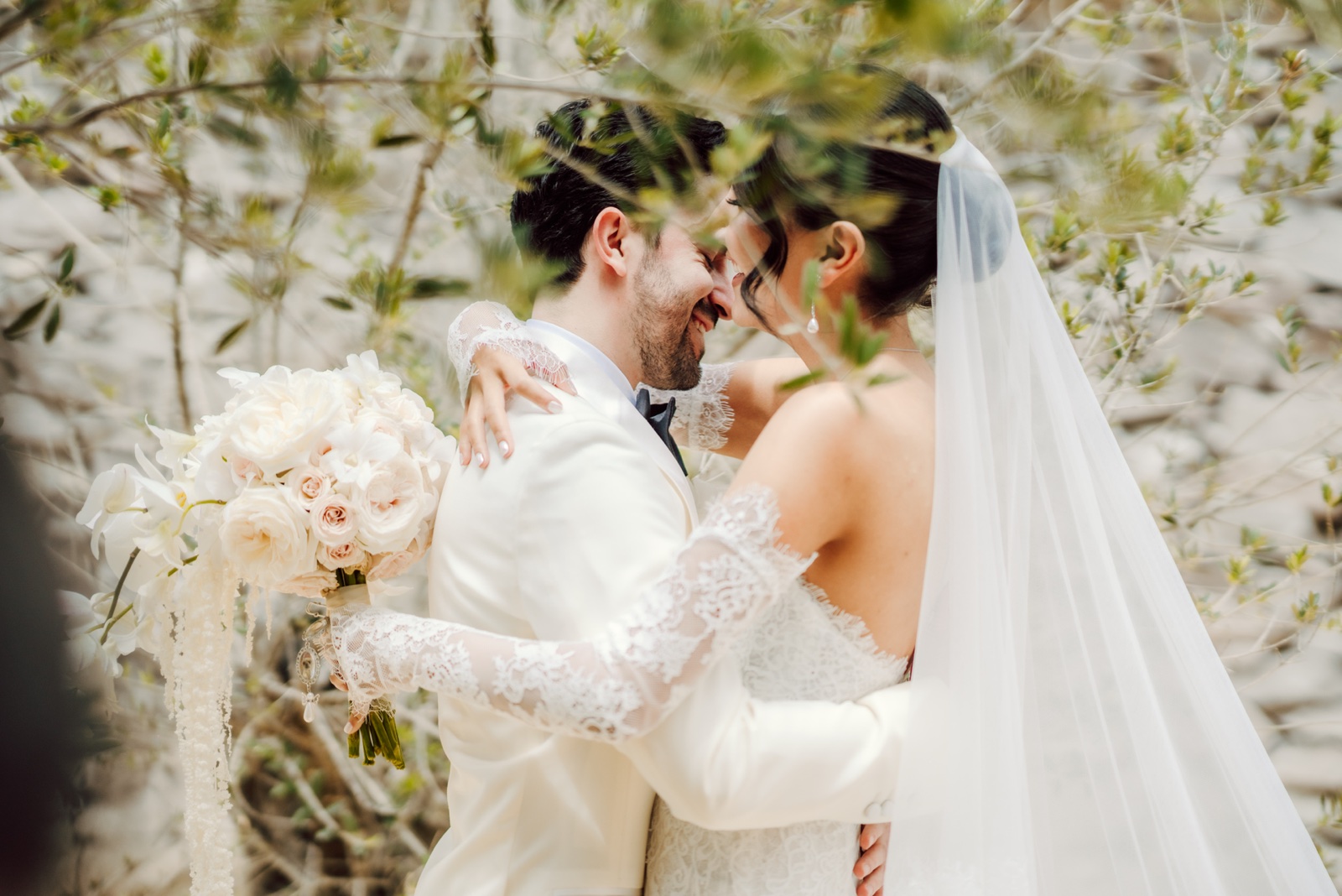 novia sosteniendo su ramo junto al novio en el jardín