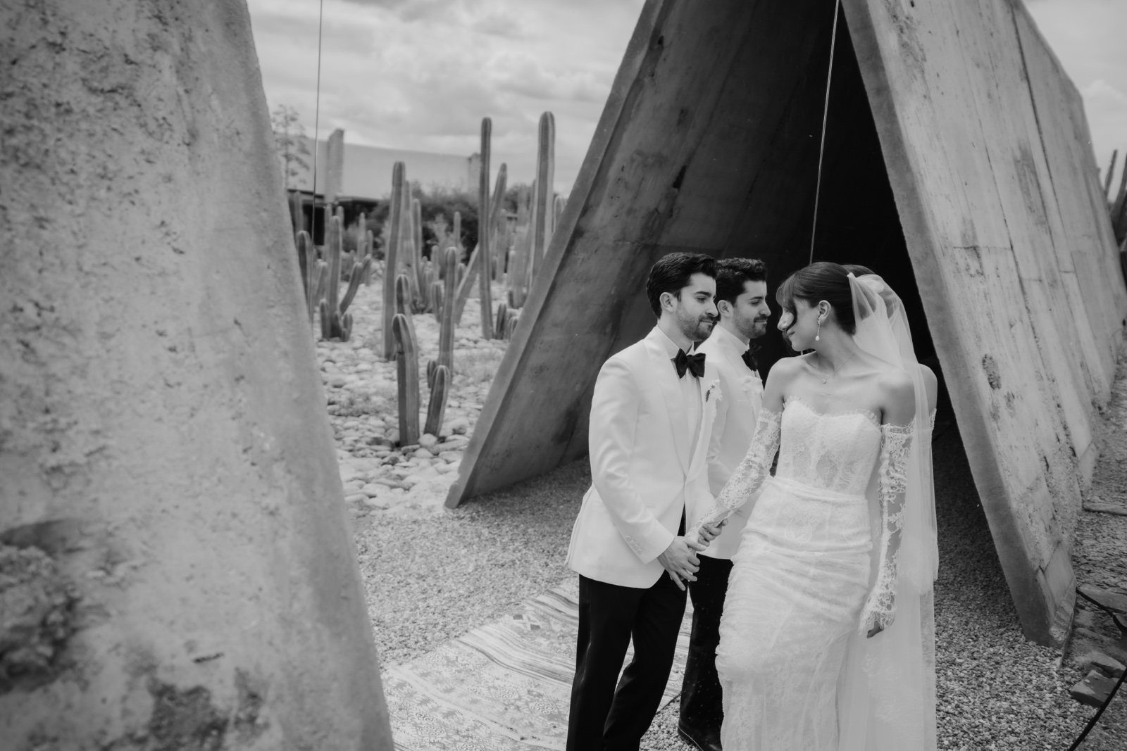 novios bajo un arco de piedra, en blanco y negro