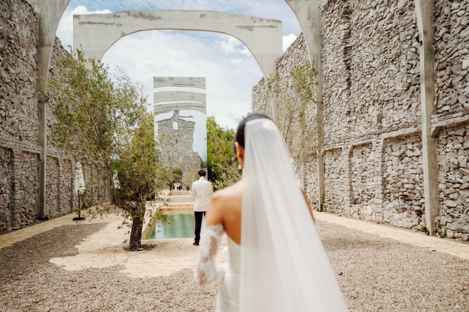 novia con velo recorriendo un pasillo de piedra