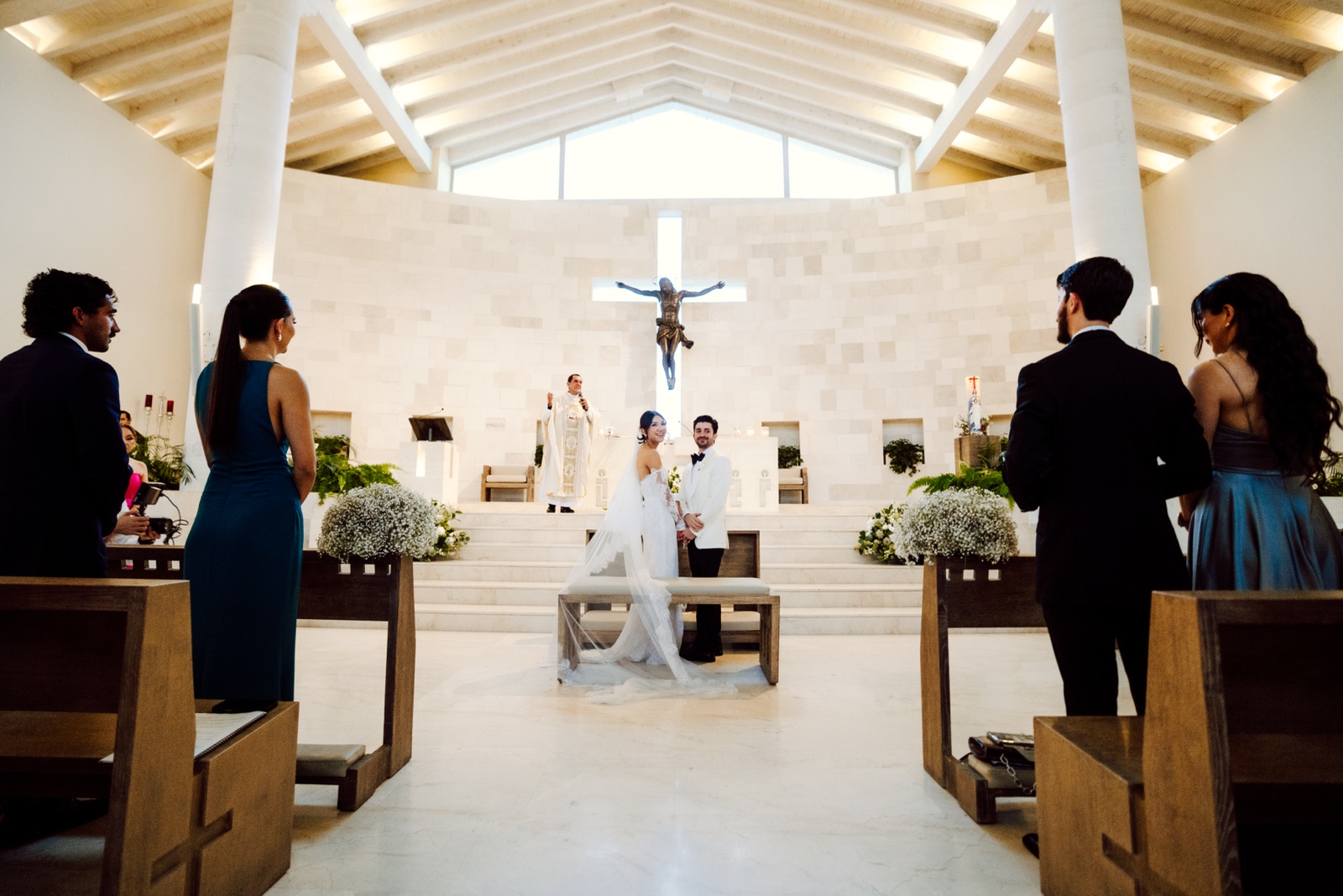 novios frente al altar rodeados de invitados
