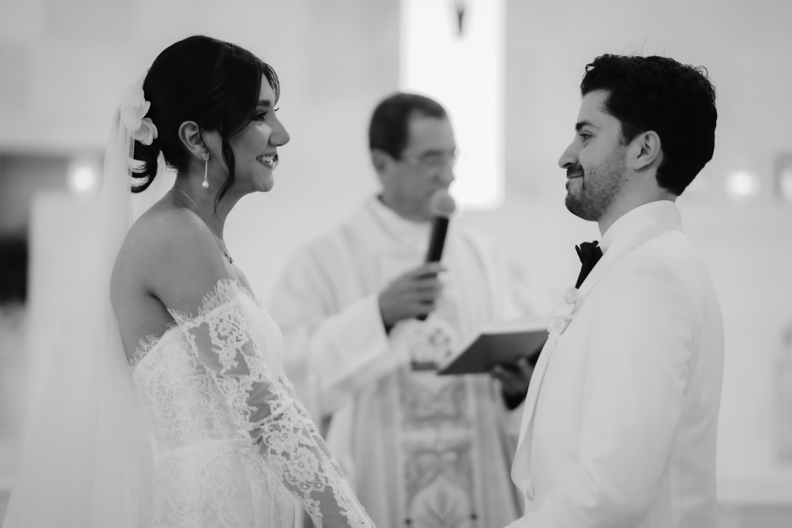 novios intercambiando miradas durante la ceremonia, en blanco y negro