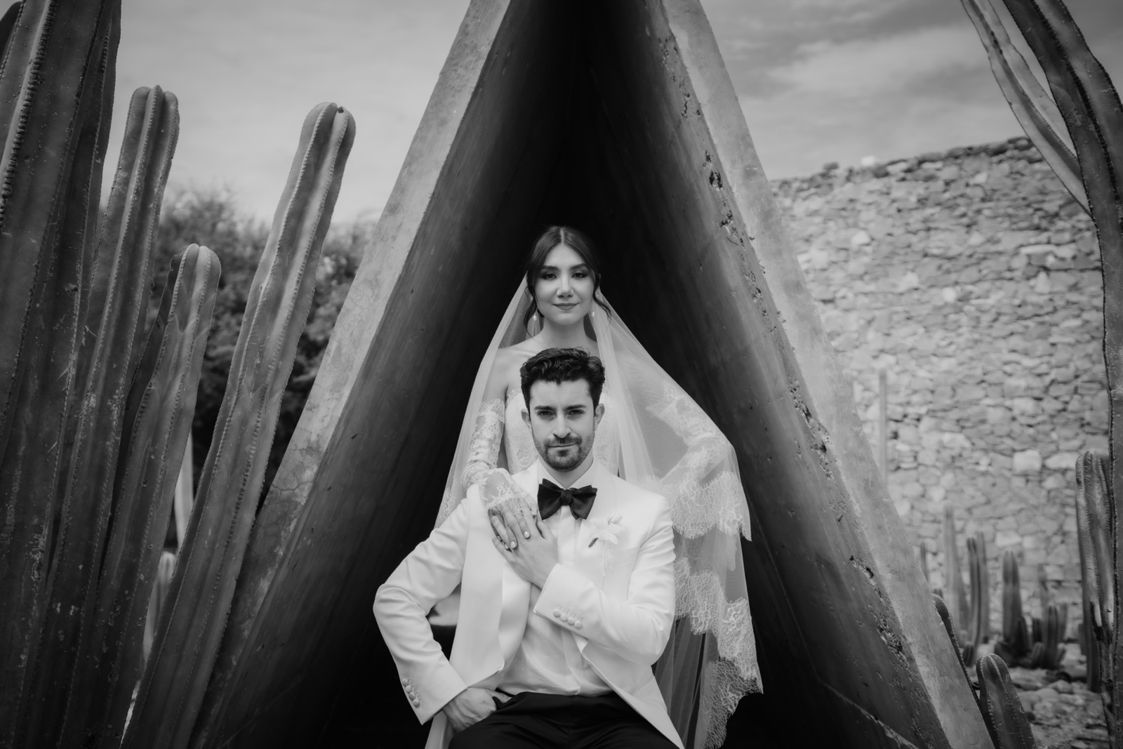 novia frente a una estructura triangular de madera, en blanco y negro
