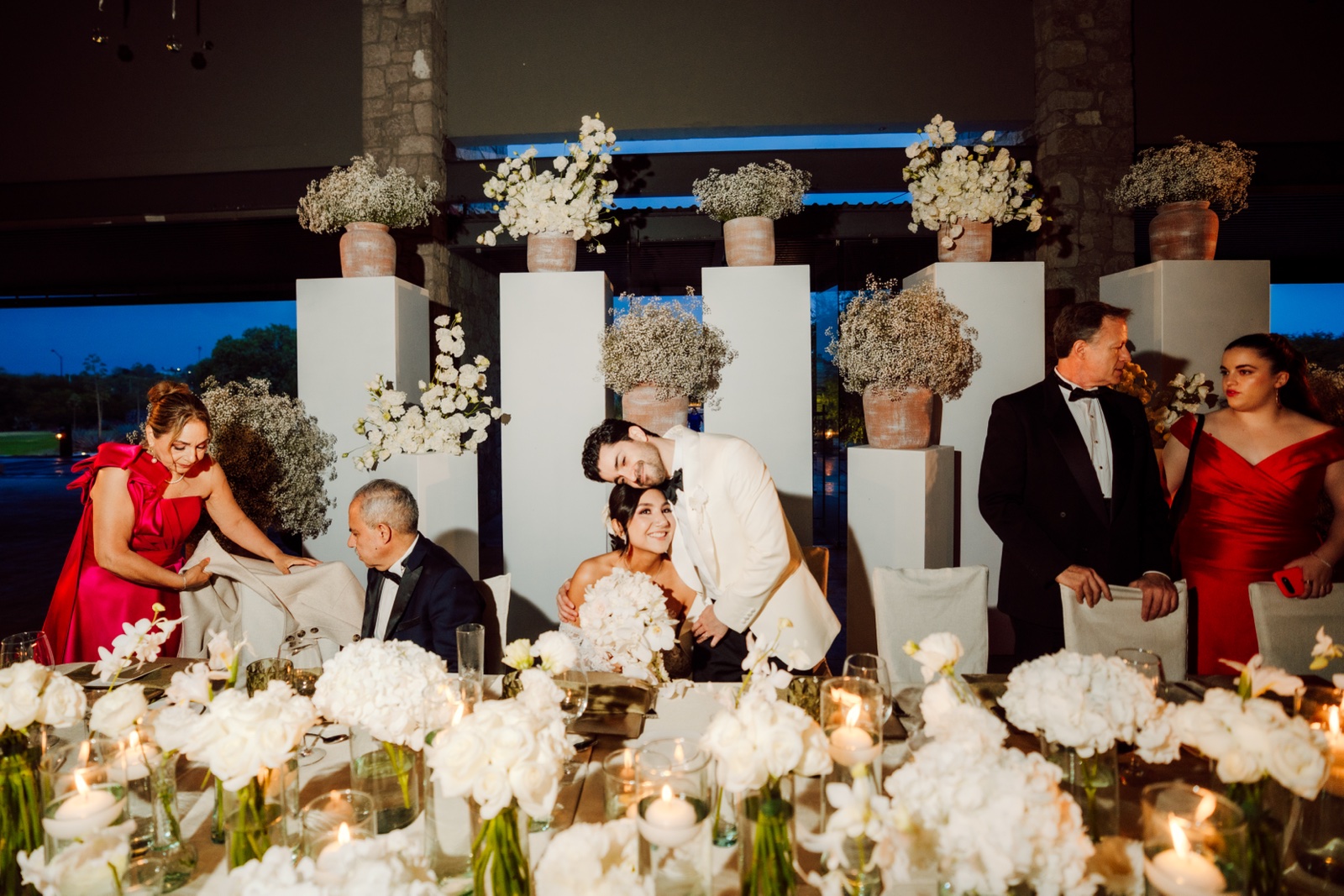 invitados brindando alrededor de una mesa decorada con flores