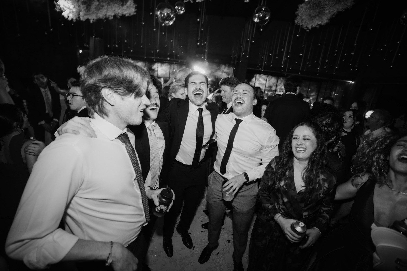 novio entre invitados en la pista de baile, en blanco y negro