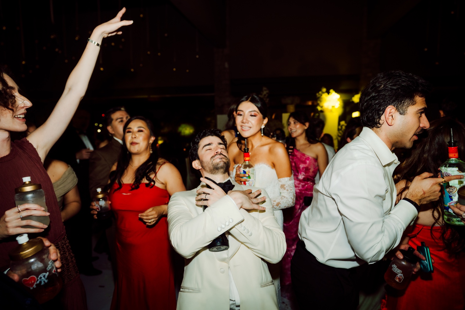 novia e invitados bailando y levantando los brazos