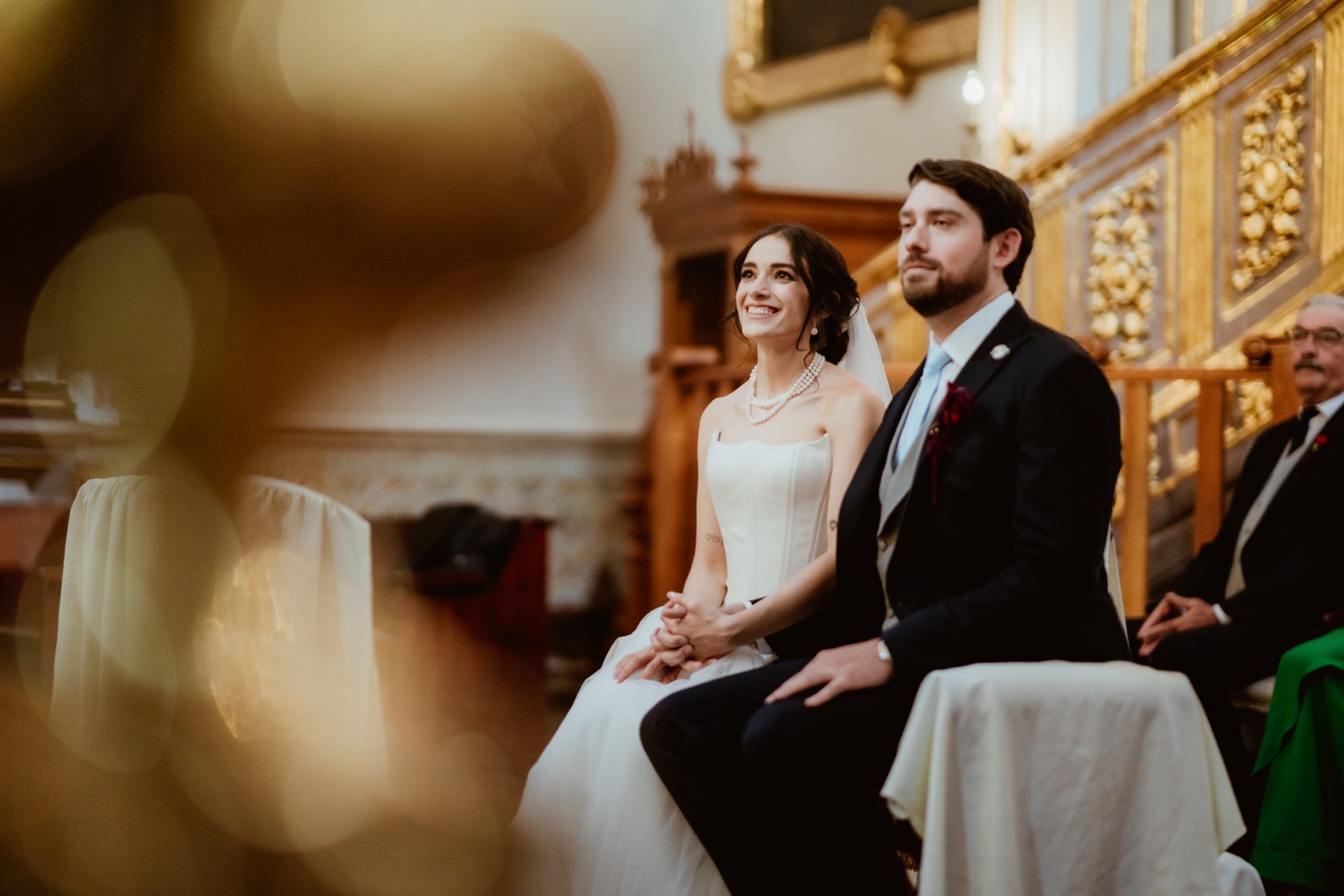 novios sentados juntos durante la ceremonia religiosa