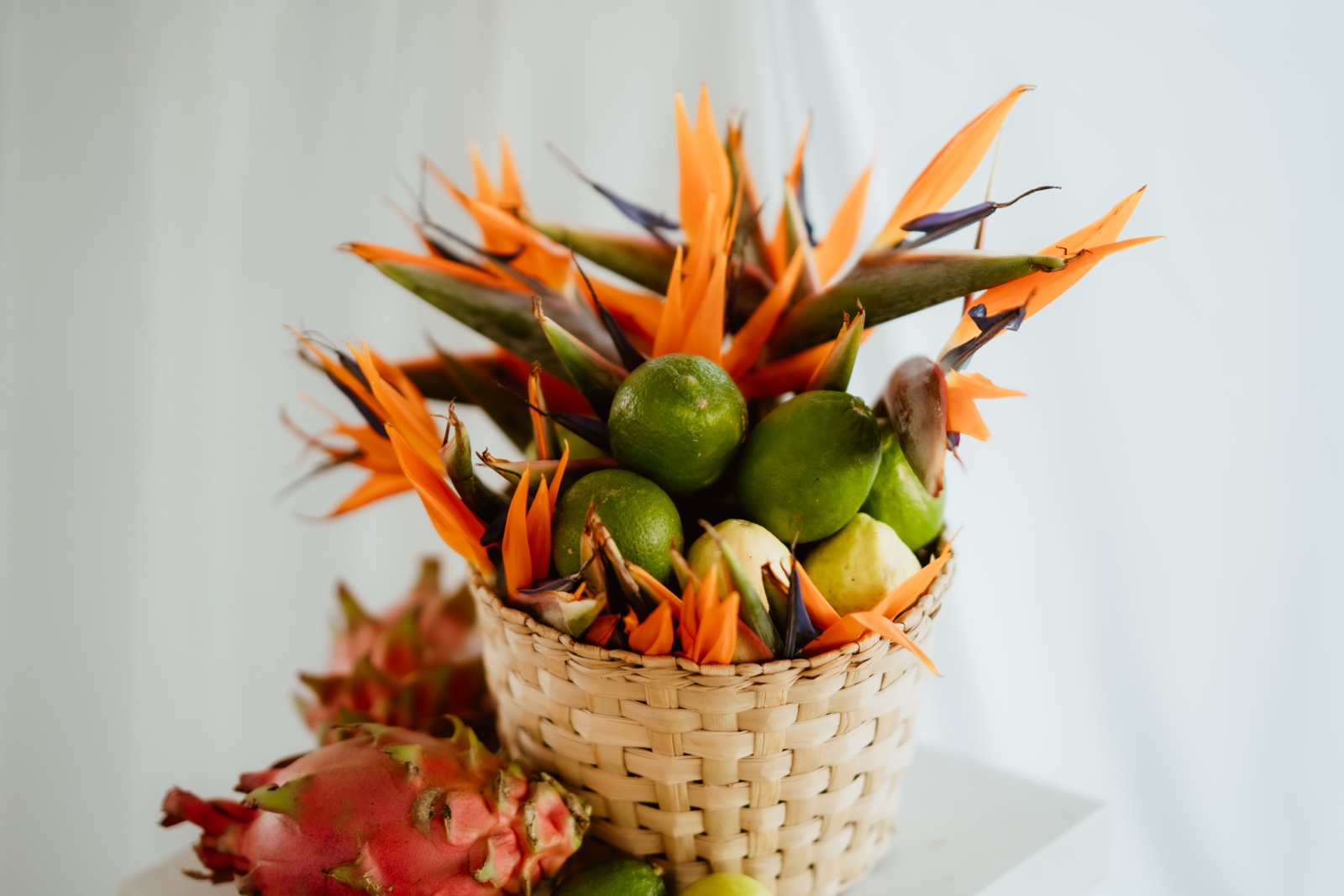 arreglo tropical con flores naranjas y frutas