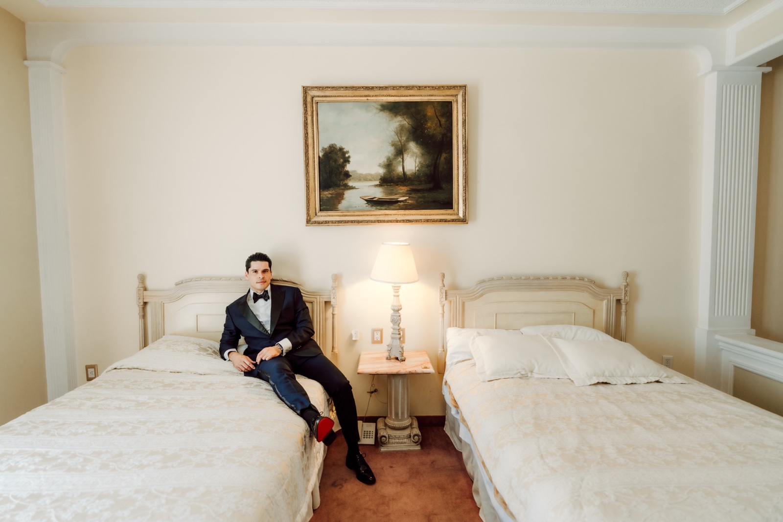 novio sentado en la cama con traje oscuro