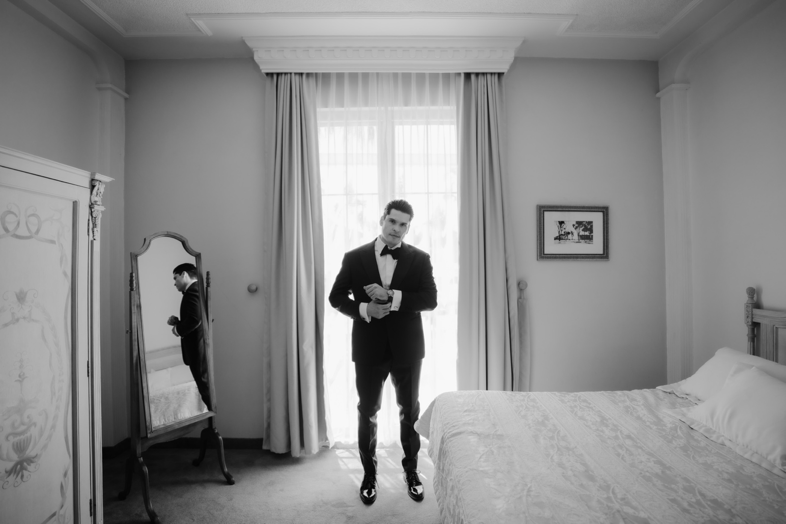 novio de pie en una habitación iluminada, en blanco y negro