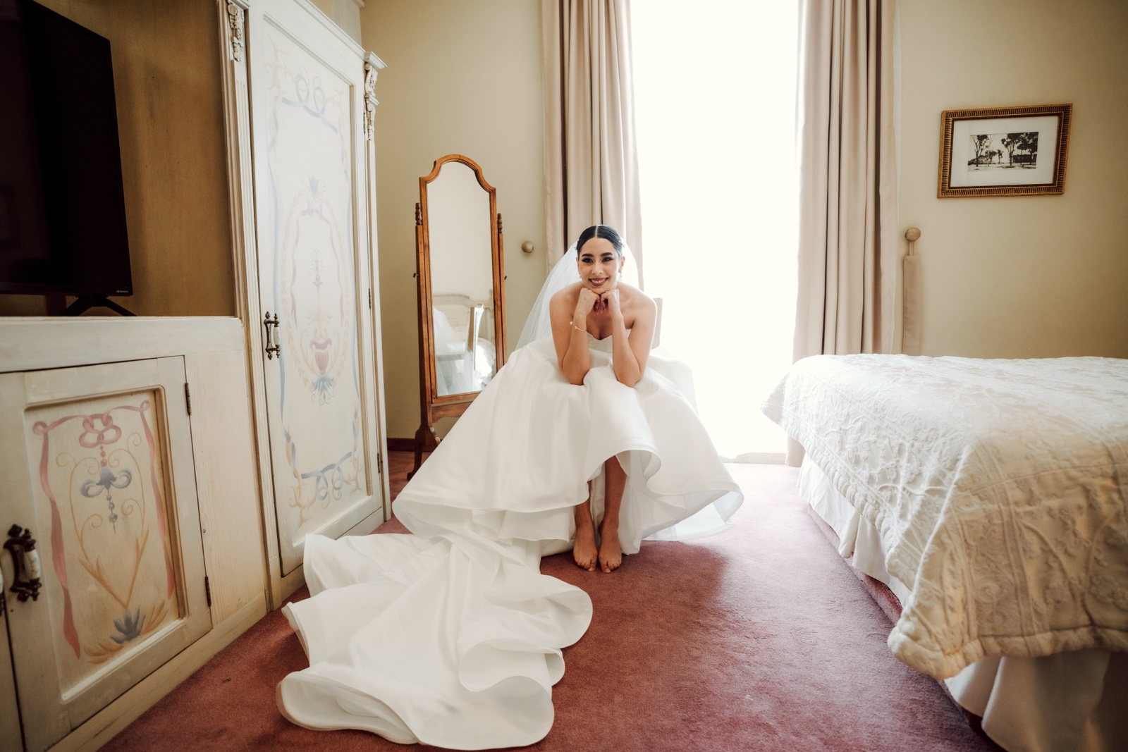 novia sentada en la cama con su vestido