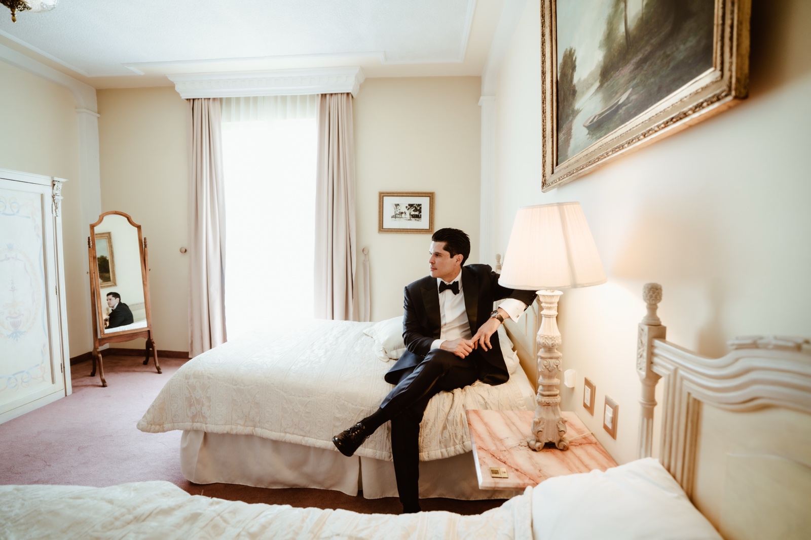 novio sentado al borde de la cama durante los preparativos