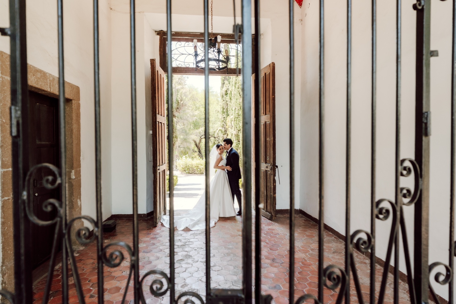 novios vistos a través de una puerta de hierro
