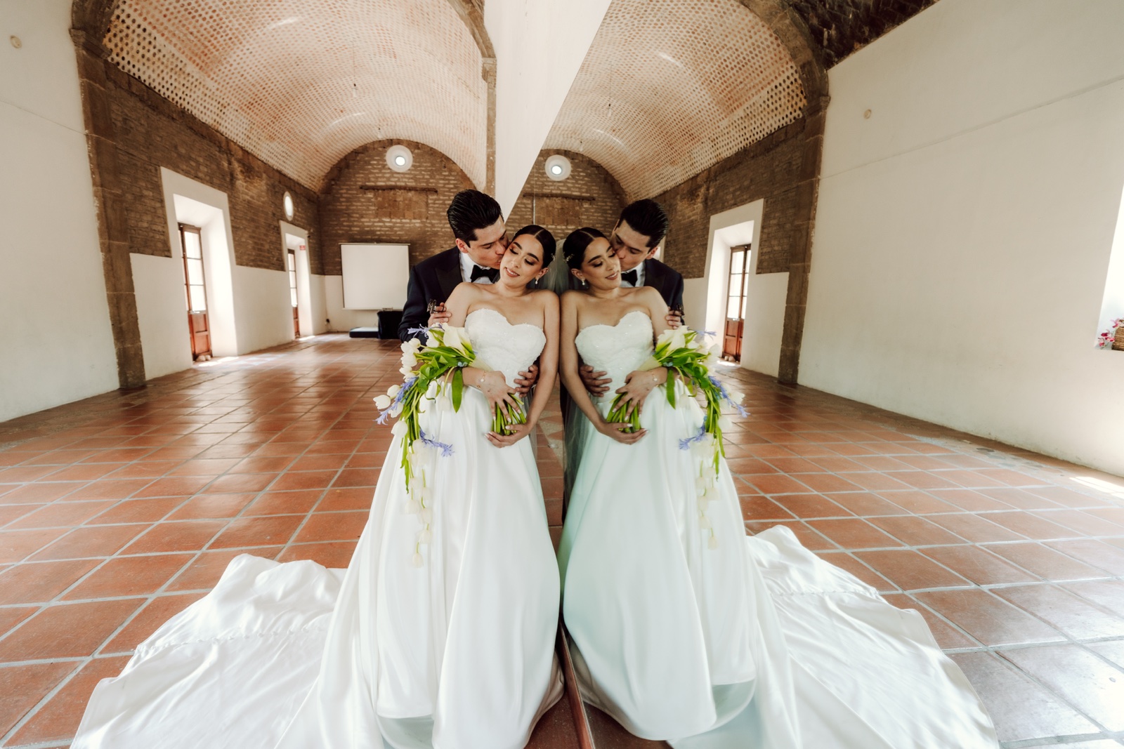 novia e invitadas levantando sus ramos en un corredor