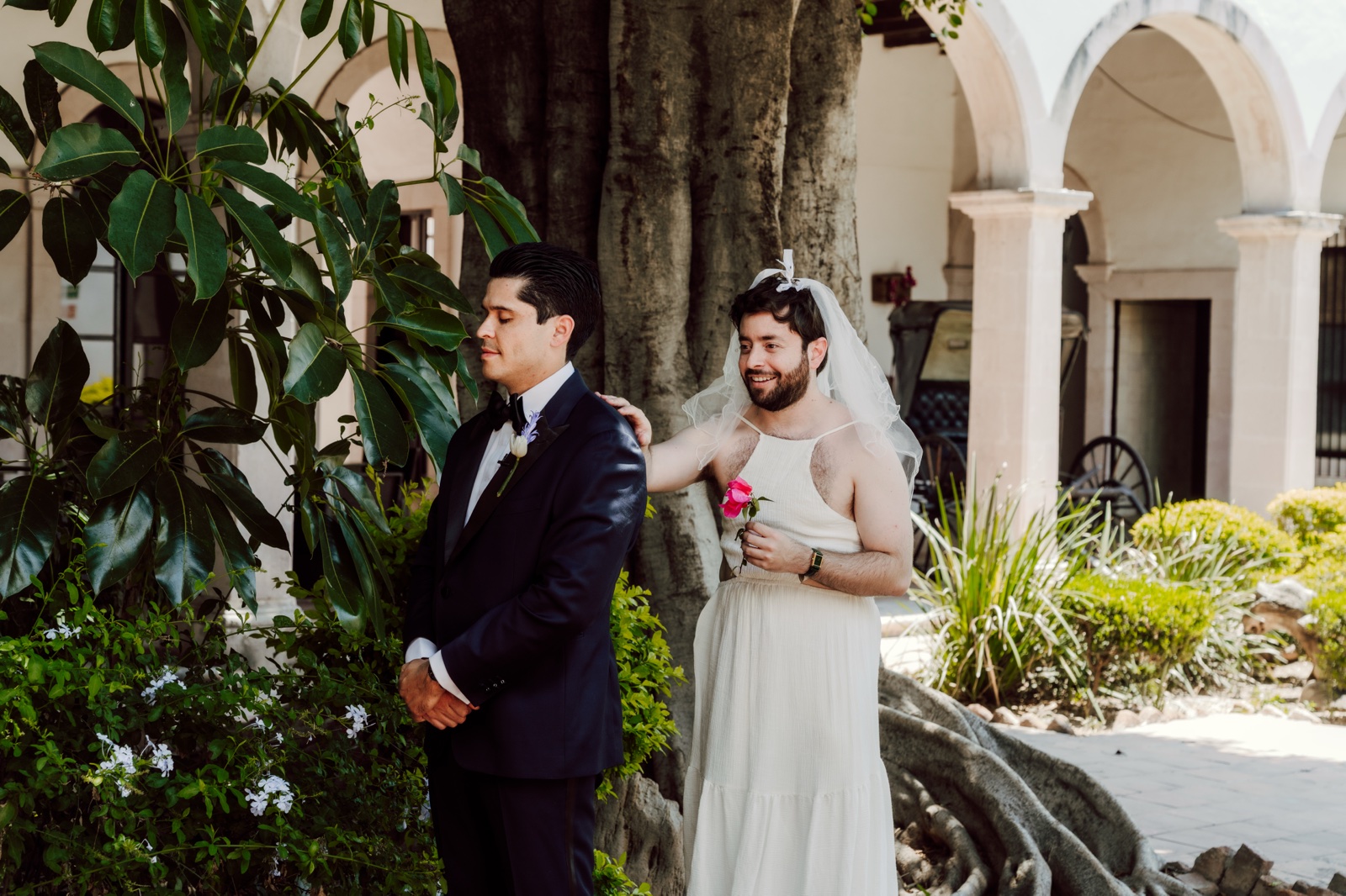 novios junto a una fachada de arcos y plantas