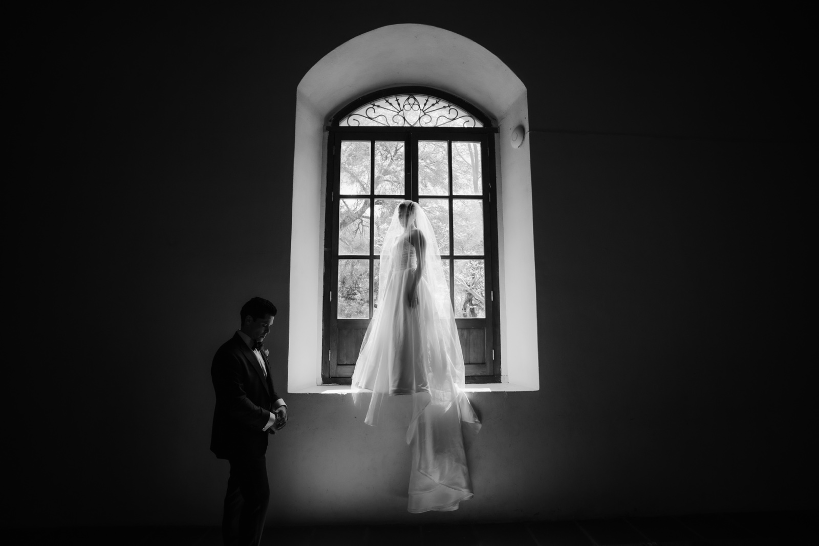 novia frente a una ventana de arco, en blanco y negro