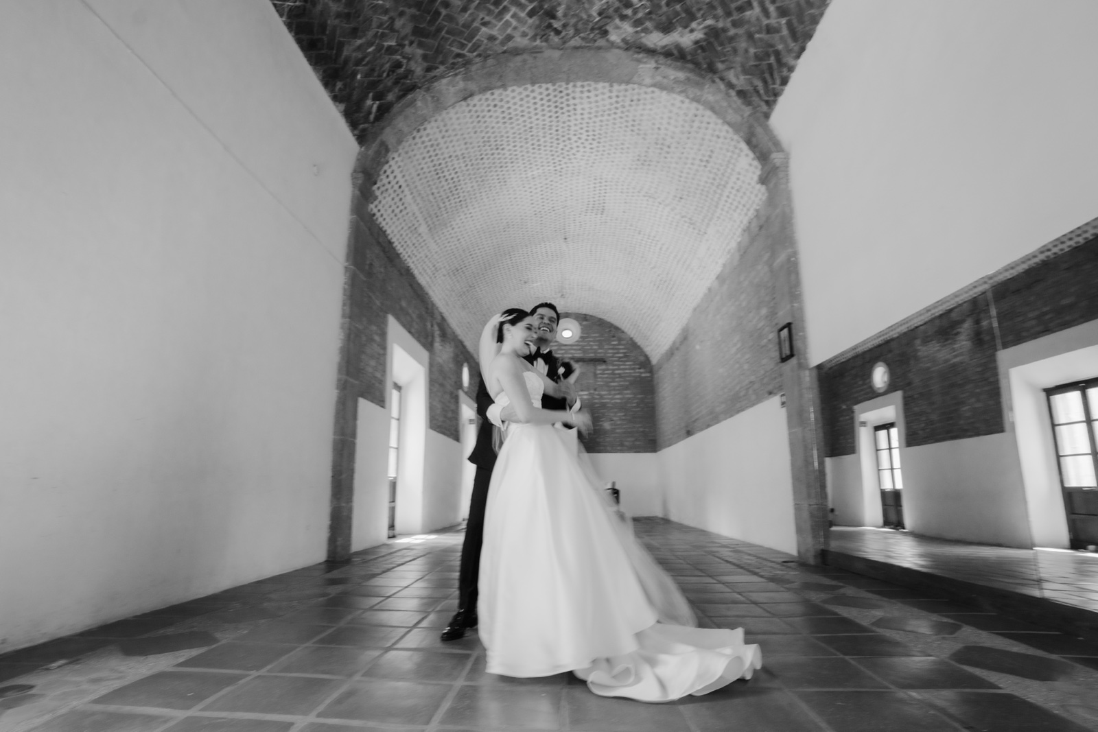 novios posando junto a una ventana, en blanco y negro